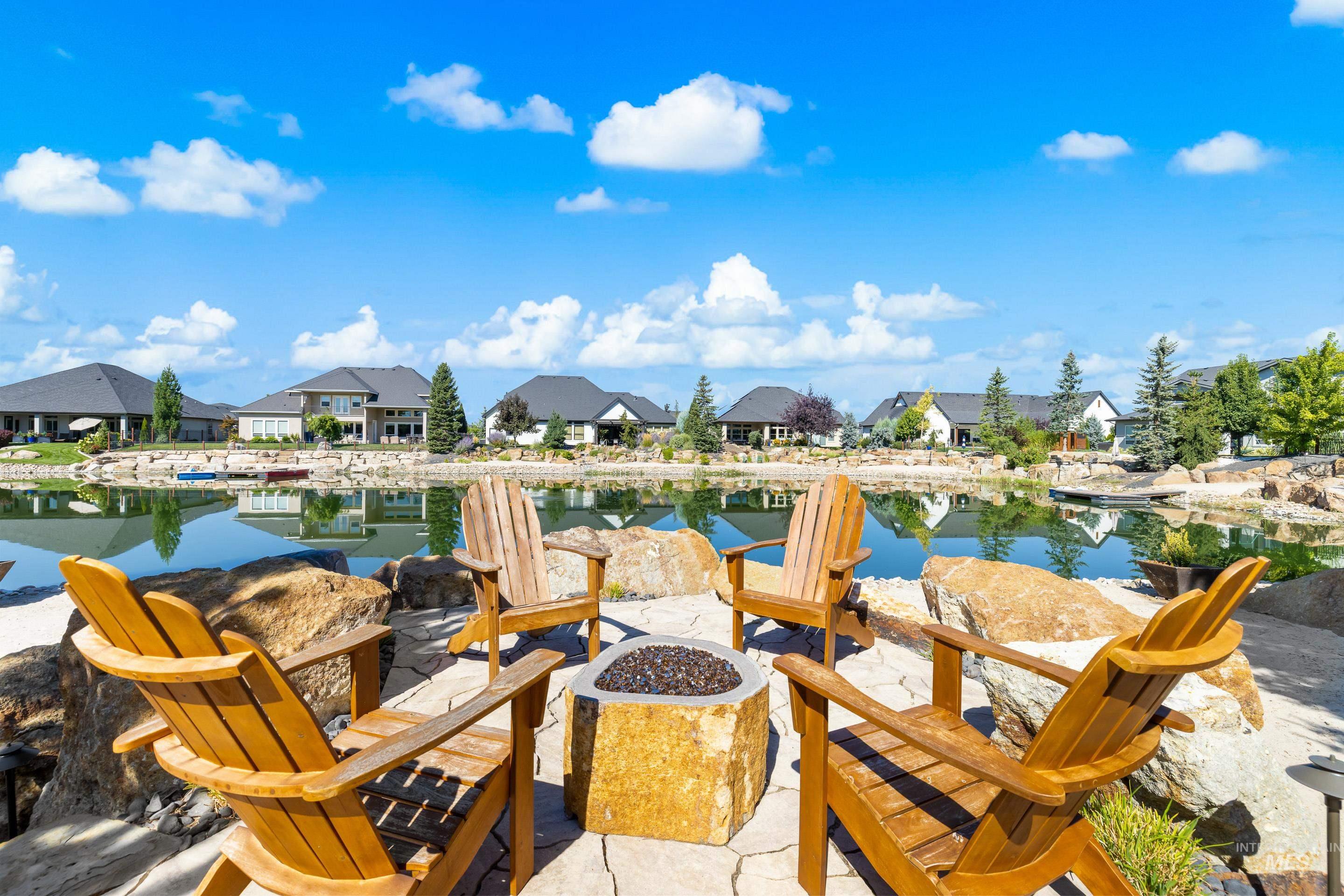 Dock area with a residential view, a water view, an outdoor fire pit, and a patio