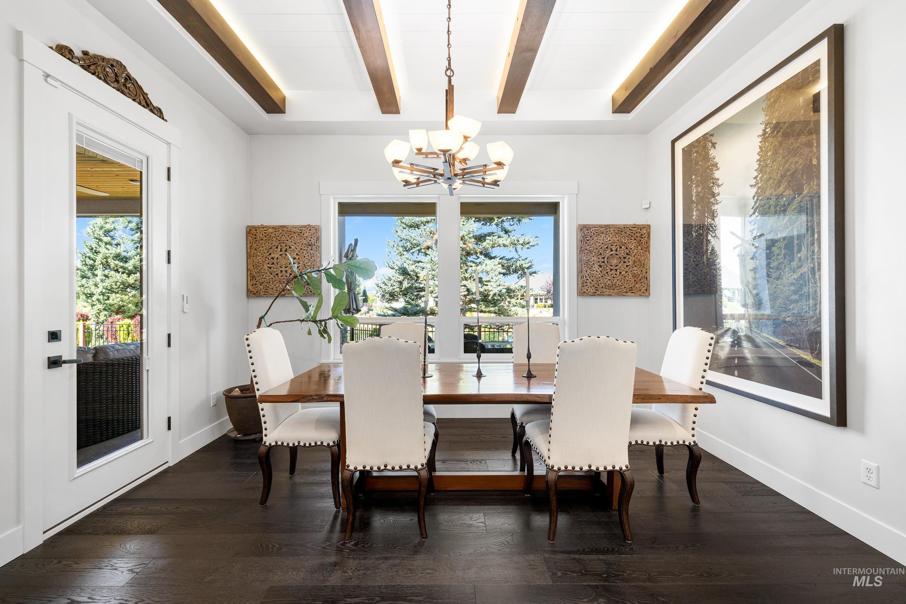 Dining room with a chandelier, dark wood-style floors, and beamed ceiling