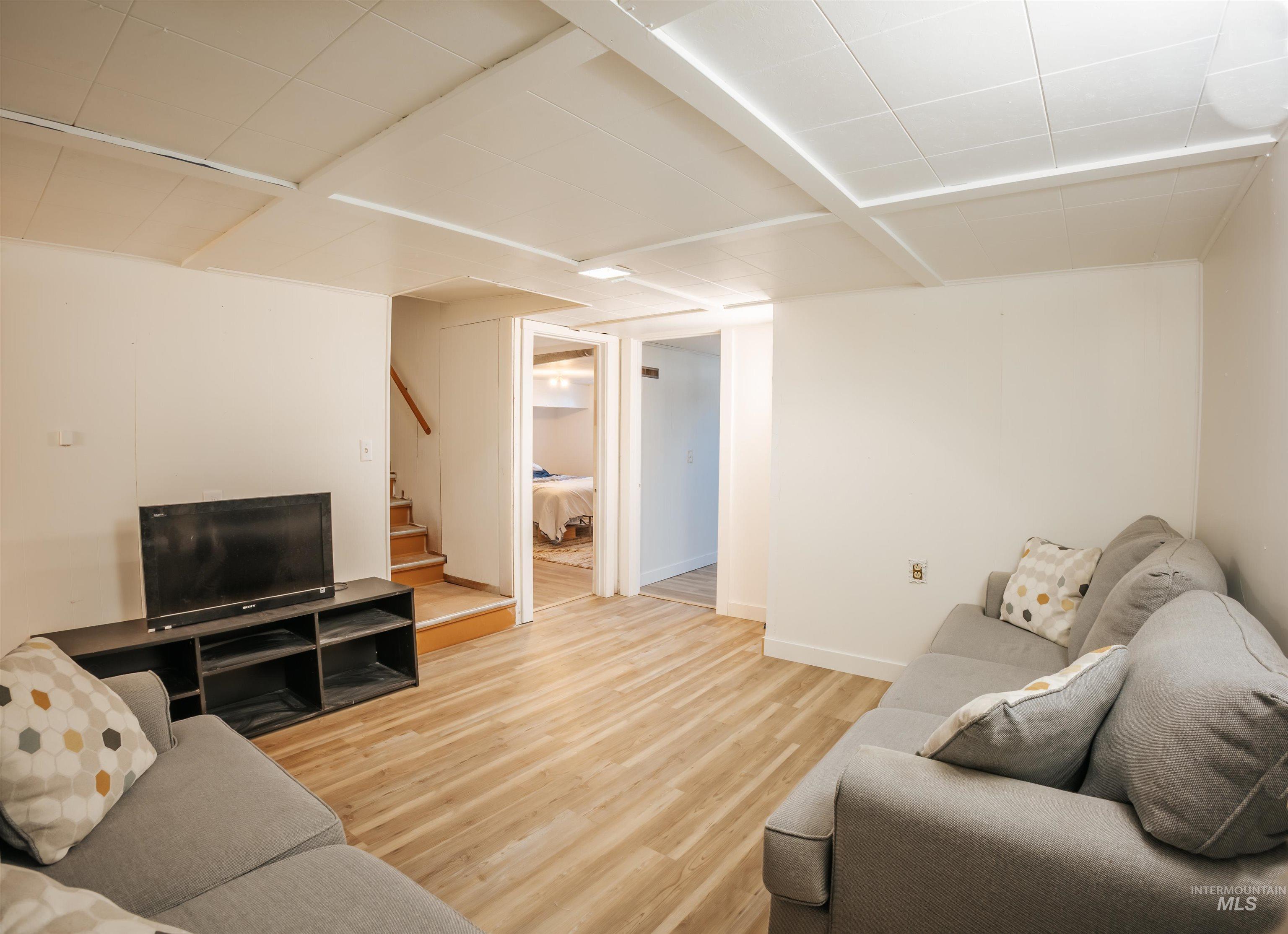 Living room featuring light wood-style flooring and stairway