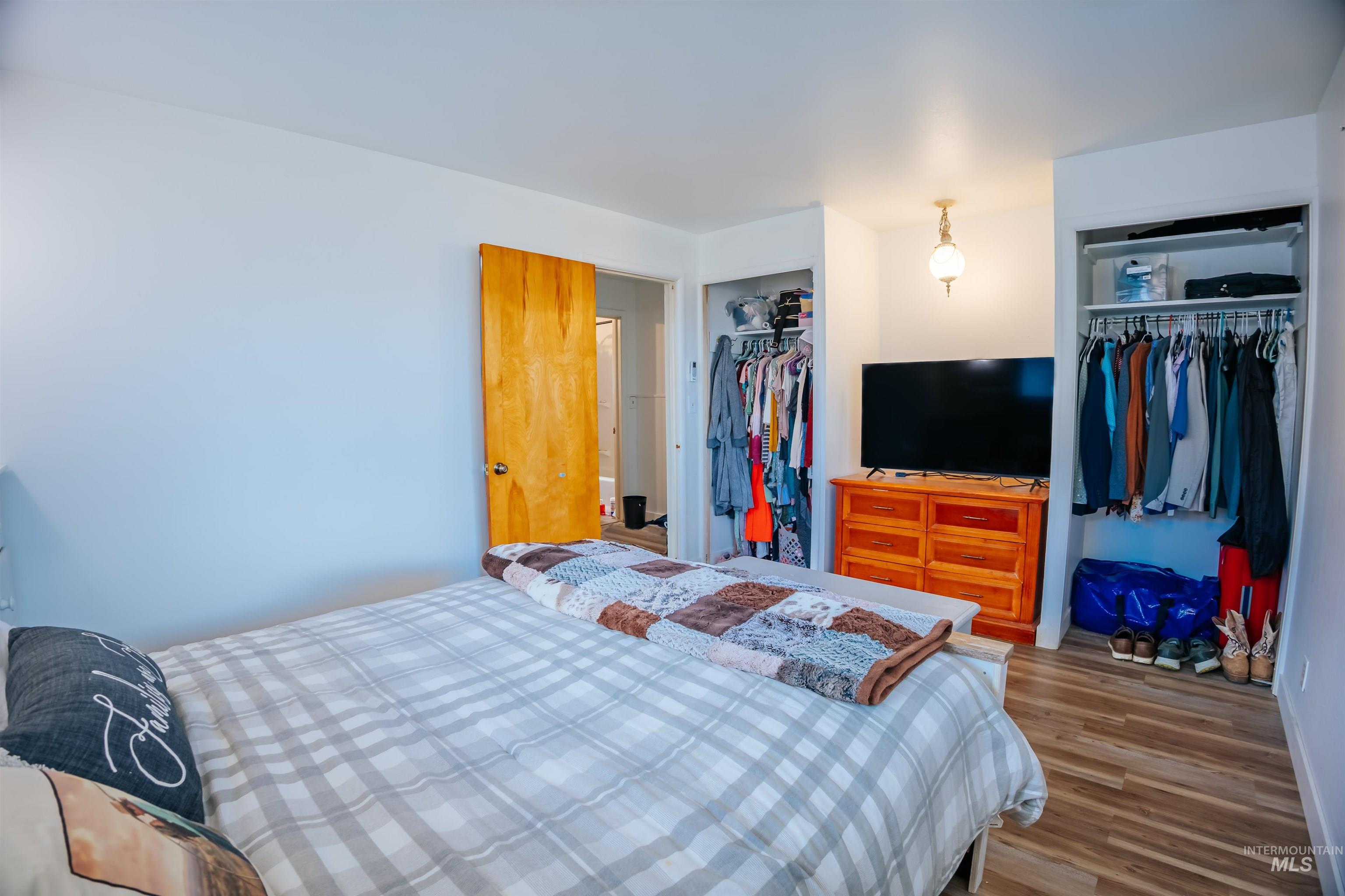 Bedroom featuring wood finished floors and multiple closets