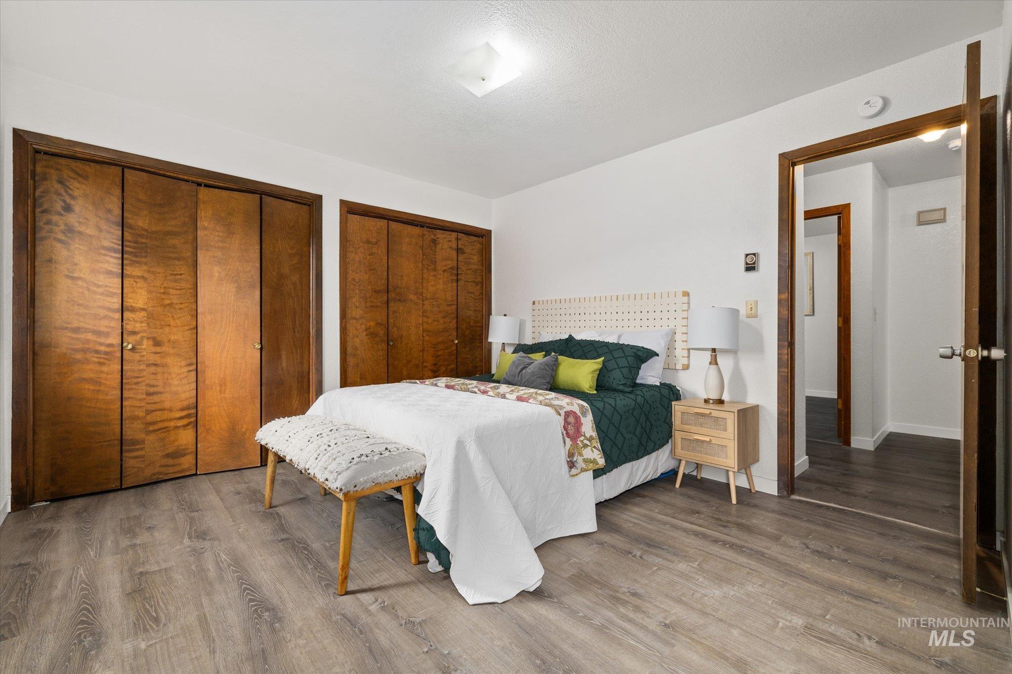 Bedroom featuring wood finished floors and multiple closets