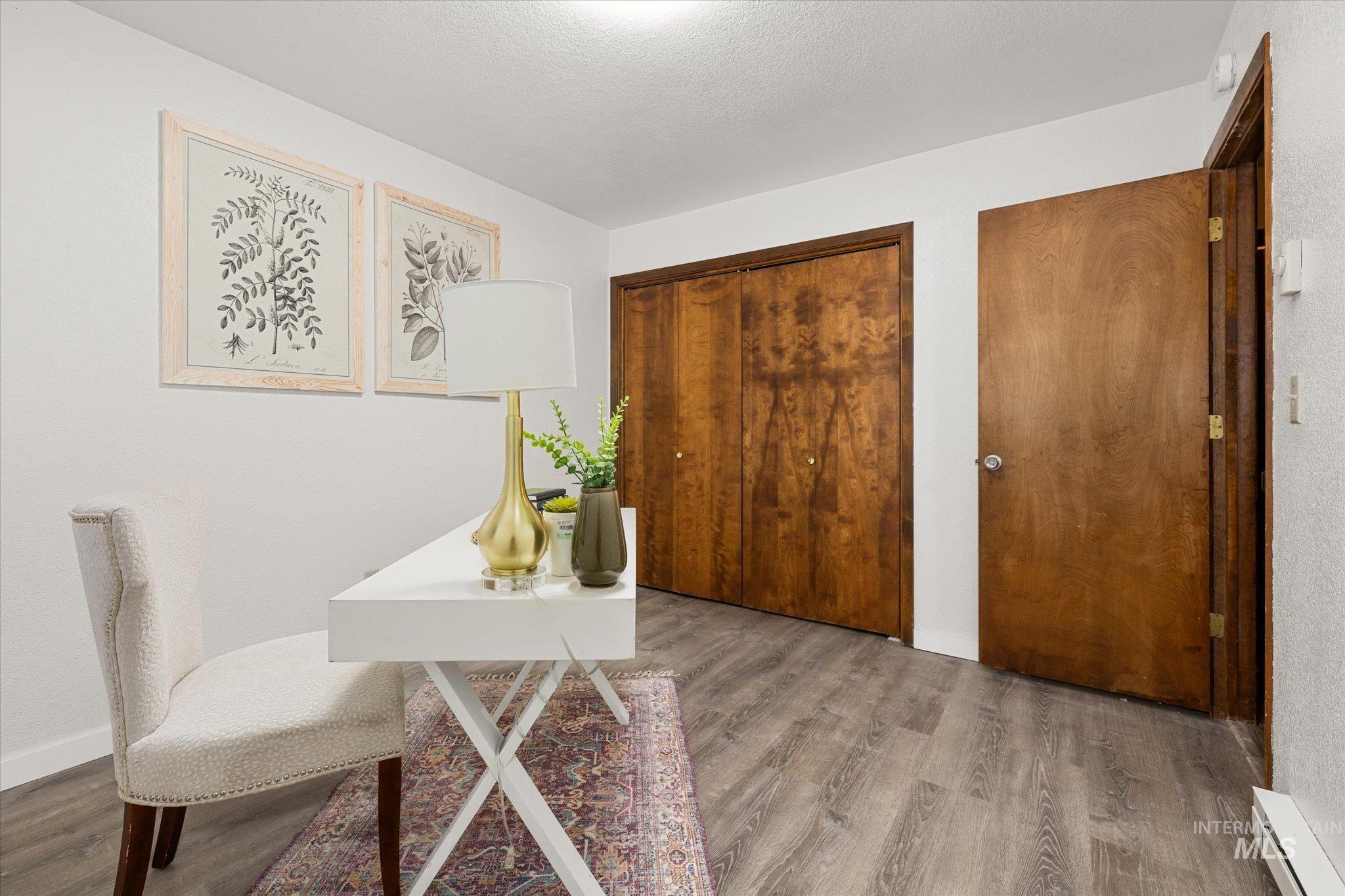 Office with wood finished floors and a baseboard heating unit