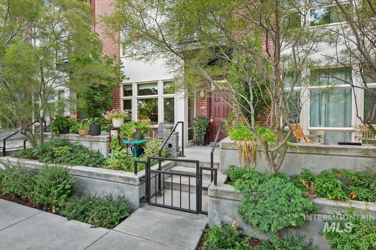 View of exterior entry with a gate and brick siding