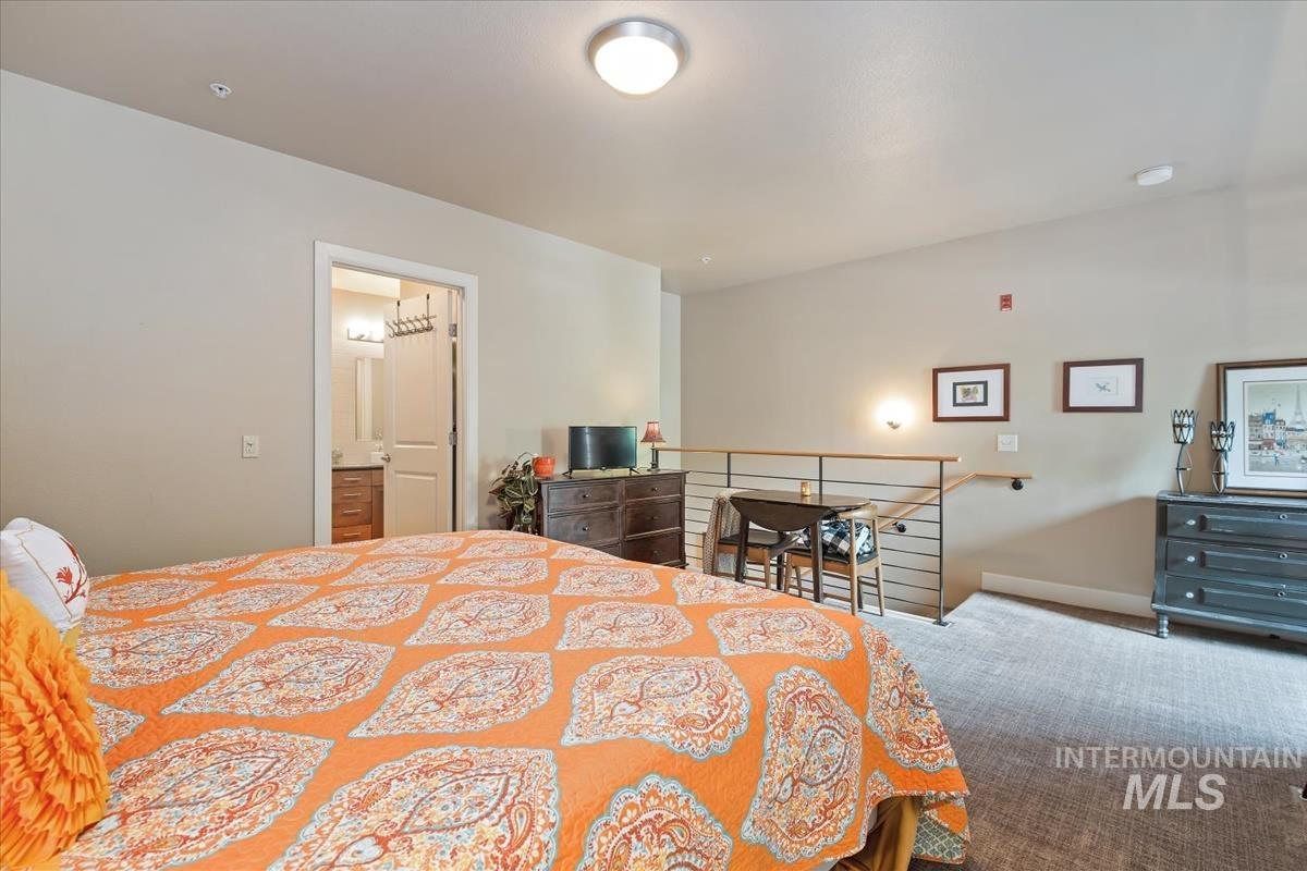 Carpeted bedroom featuring baseboards and connected bathroom