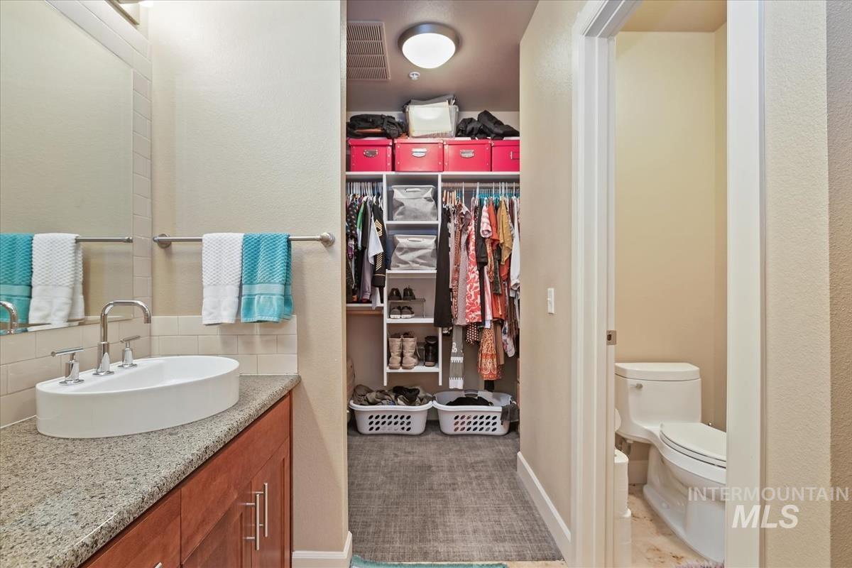 Bathroom with vanity and a spacious closet
