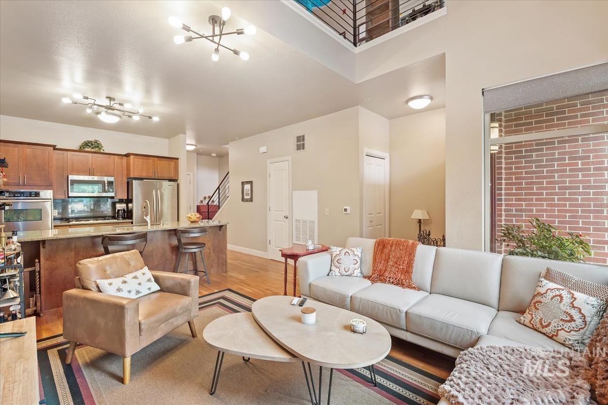 Living area with light wood-style flooring and a chandelier