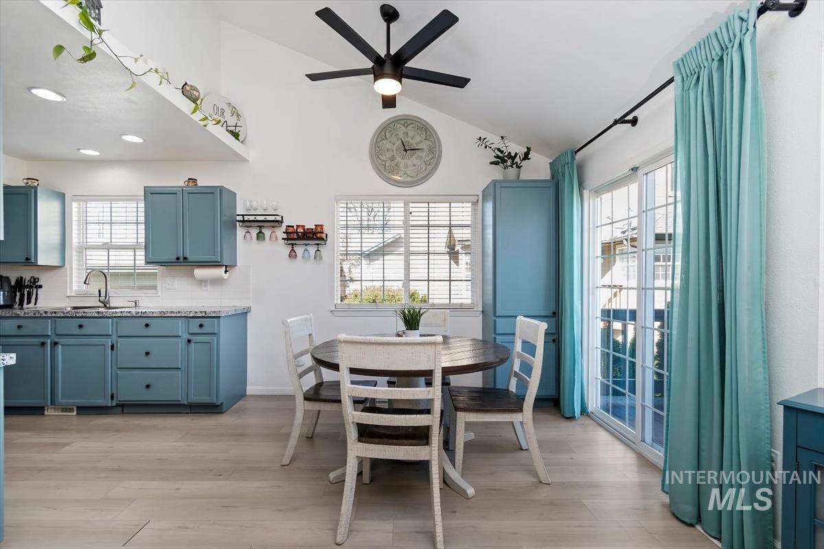 Dining room featuring lofted ceiling, a ceiling fan, and light wood-style floors