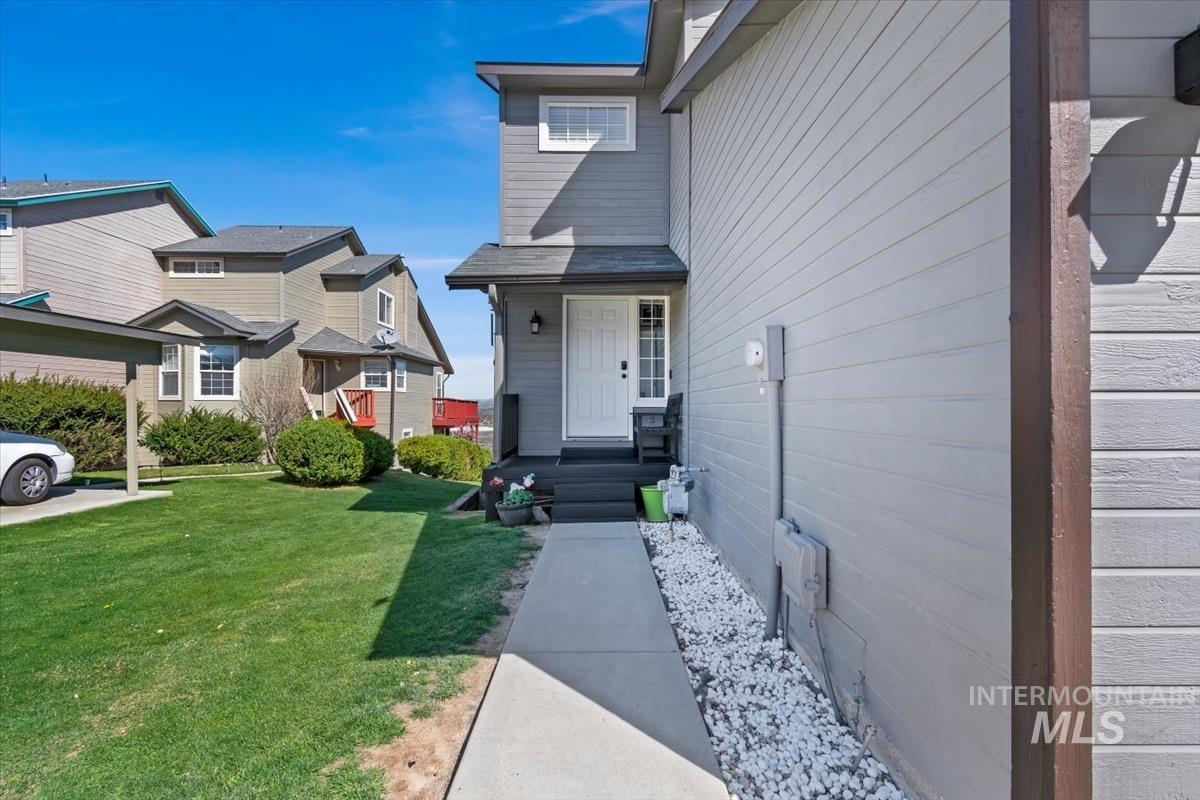 View of exterior entry featuring a lawn