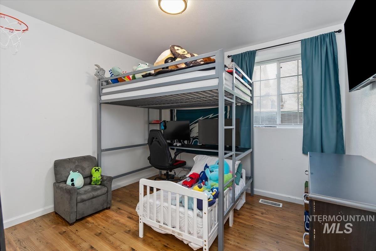 Bedroom with an office area and wood finished floors