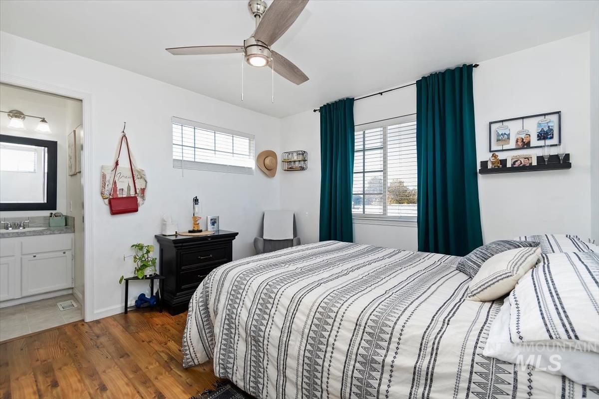 Bedroom featuring dark wood finished floors, ceiling fan, and connected bathroom