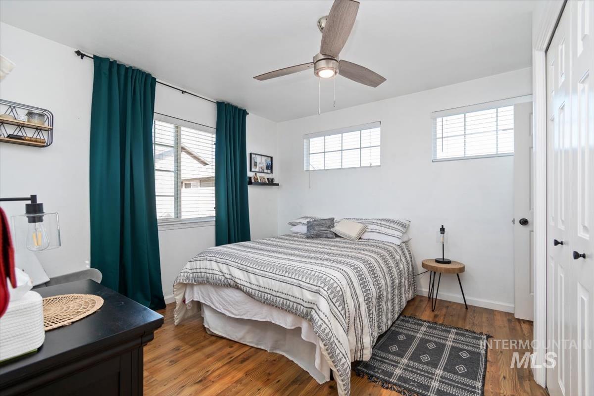 Bedroom with hardwood / wood-style floors, ceiling fan, and a closet