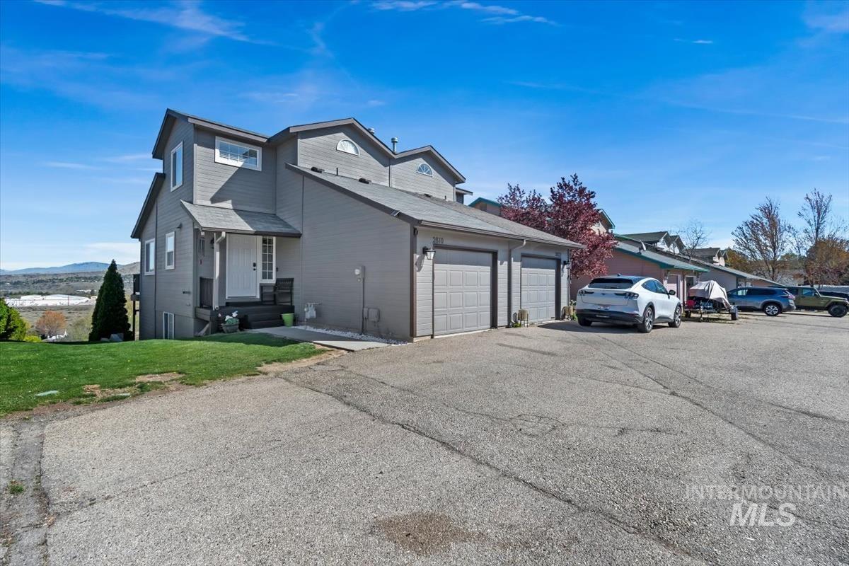 View of property exterior with a garage, a yard, and driveway