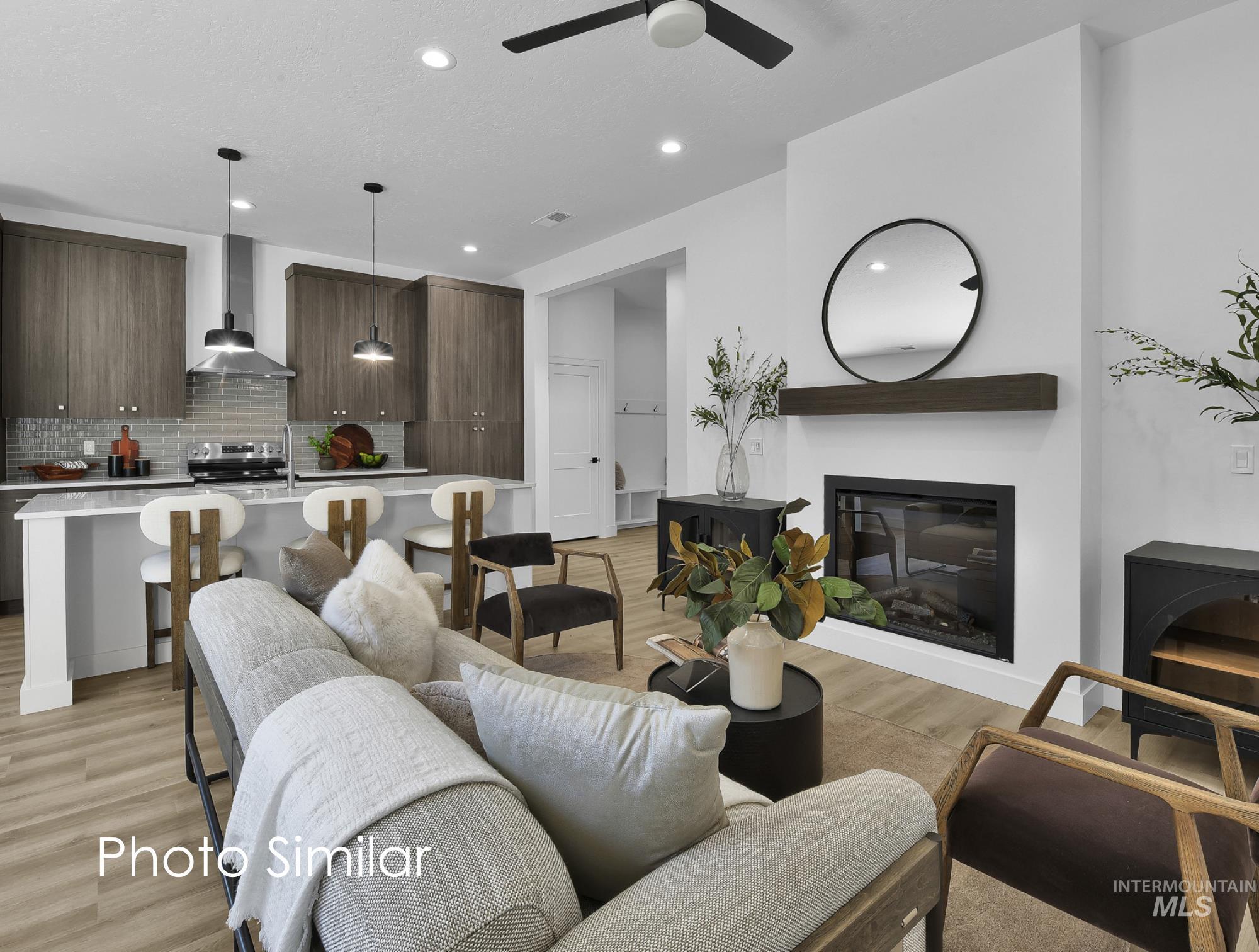 Open-concept living space featuring a modern linear fireplace with a dark wood mantel, wood-finish flooring, recessed lighting, and a contemporary ceiling fan