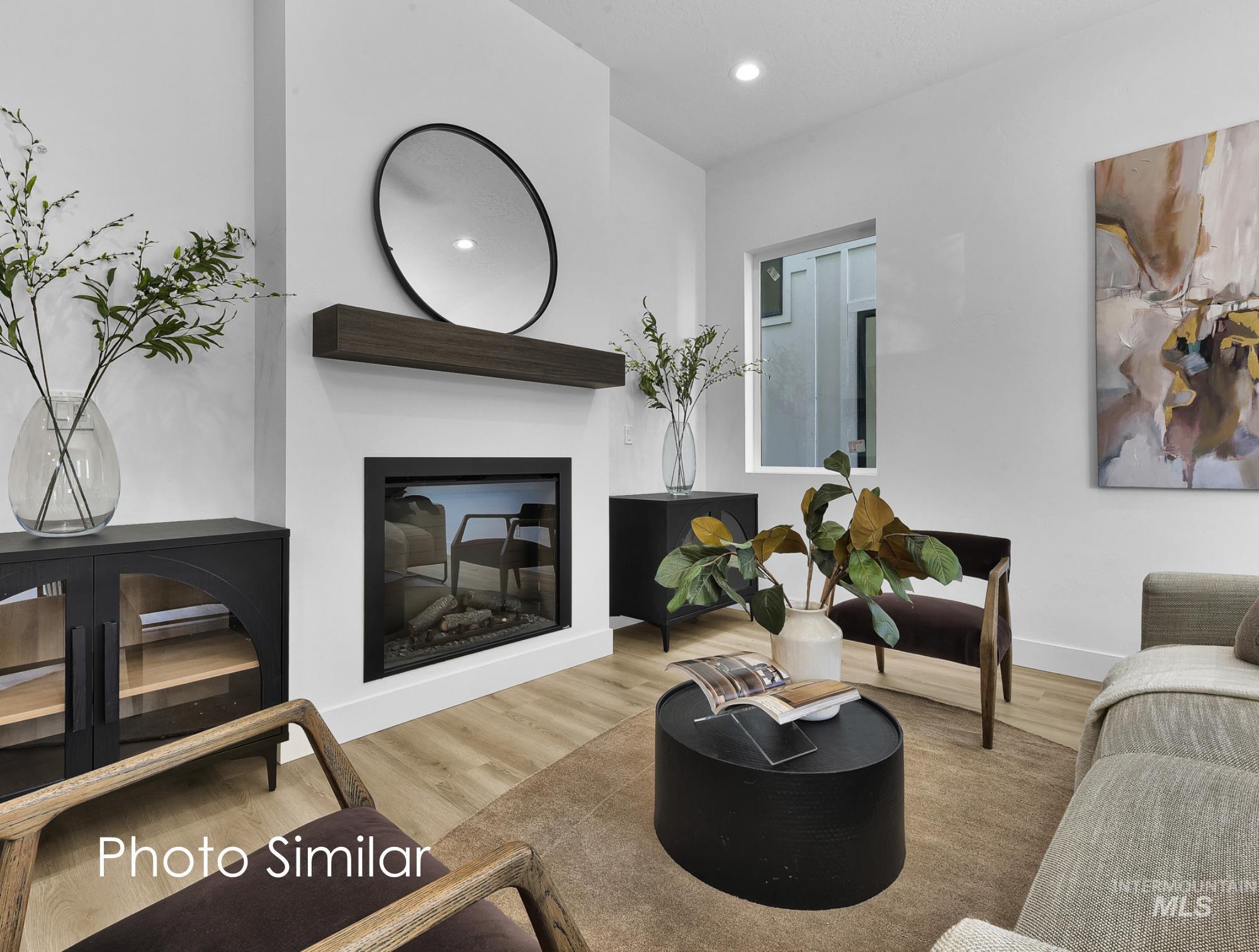Contemporary living area featuring a built-in fireplace with a dark wood-finish mantel and a framed glass insert