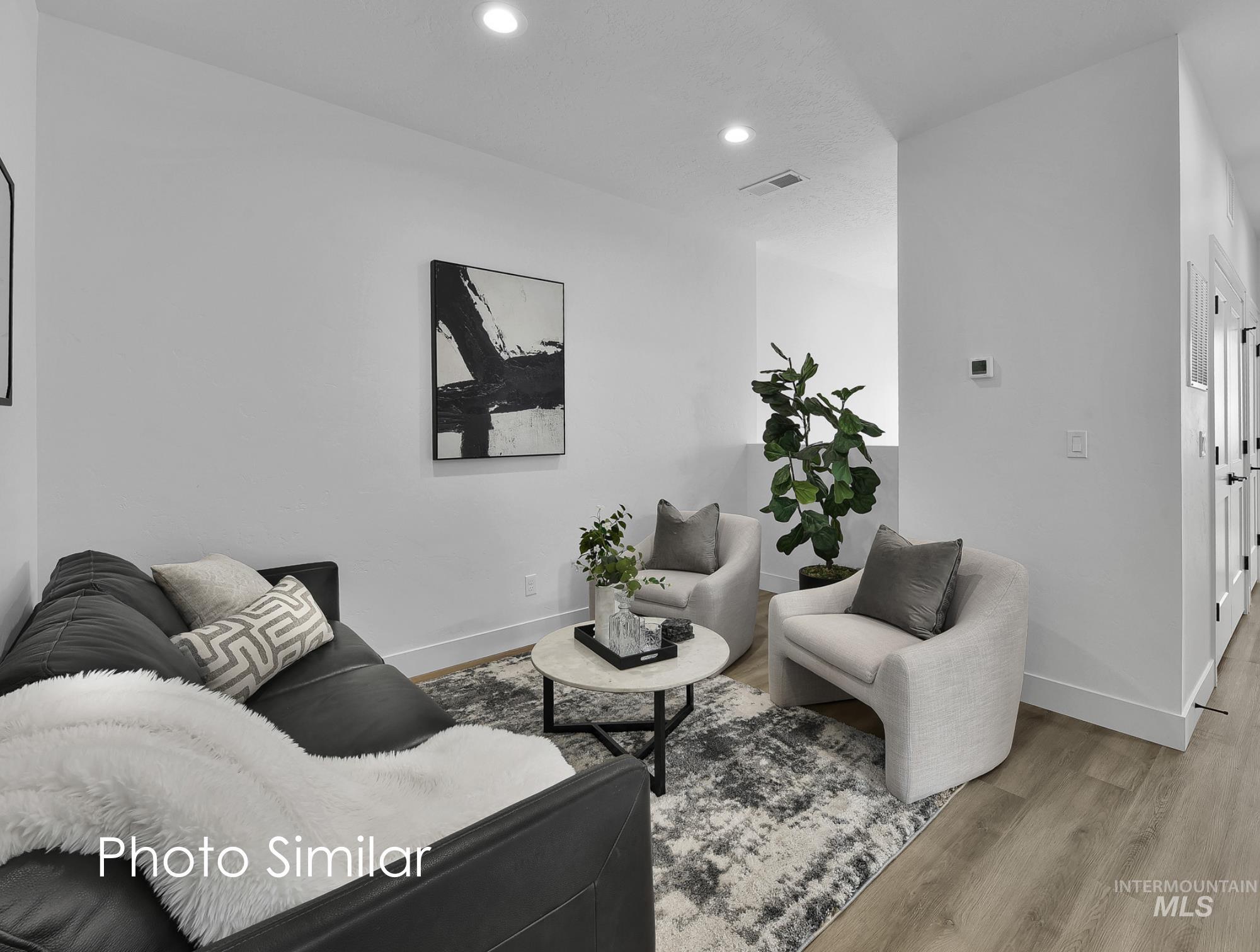 Living area featuring light wood-finish flooring and recessed lighting