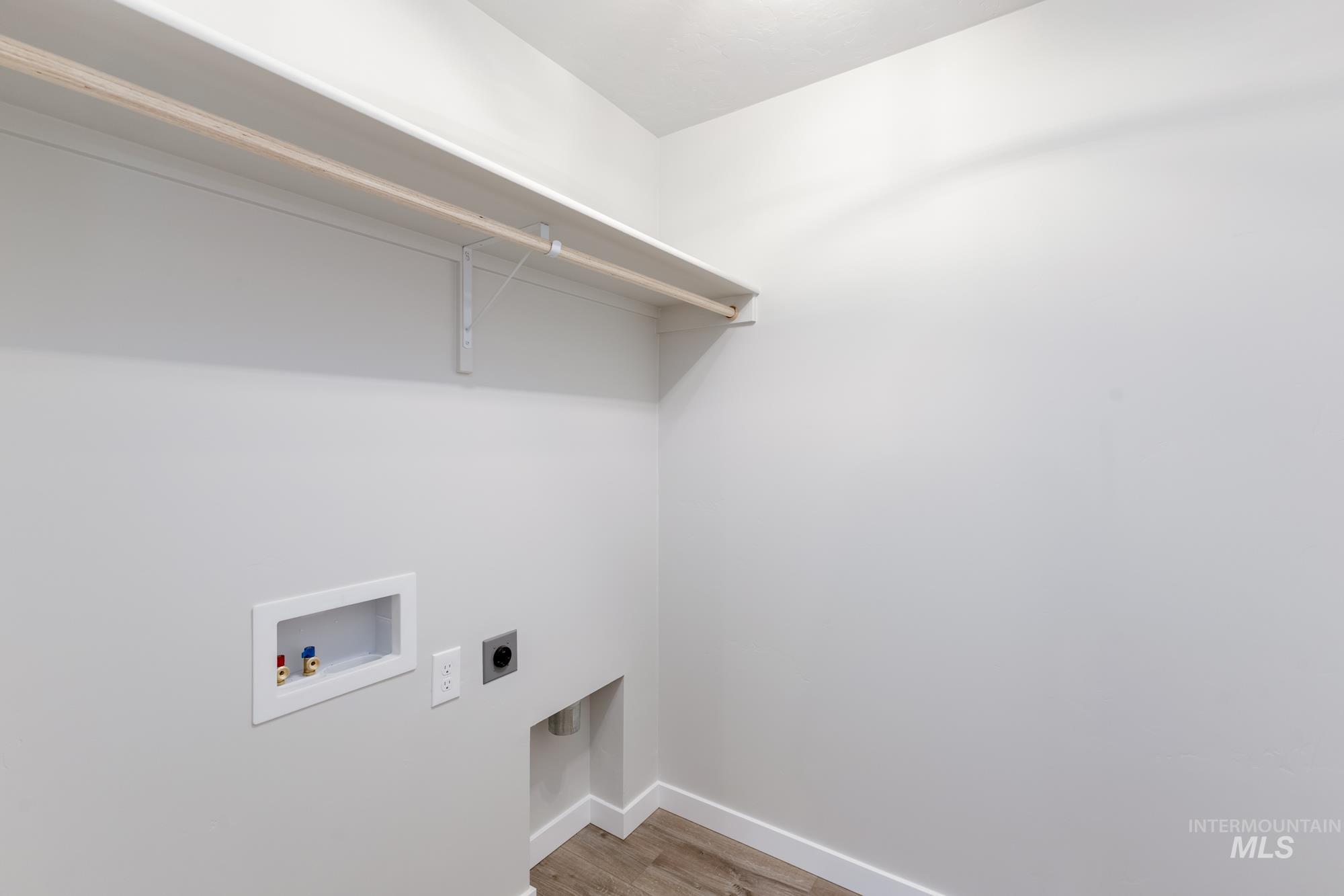 Washroom featuring light wood-style flooring, hookup for an electric dryer, and washer hookup