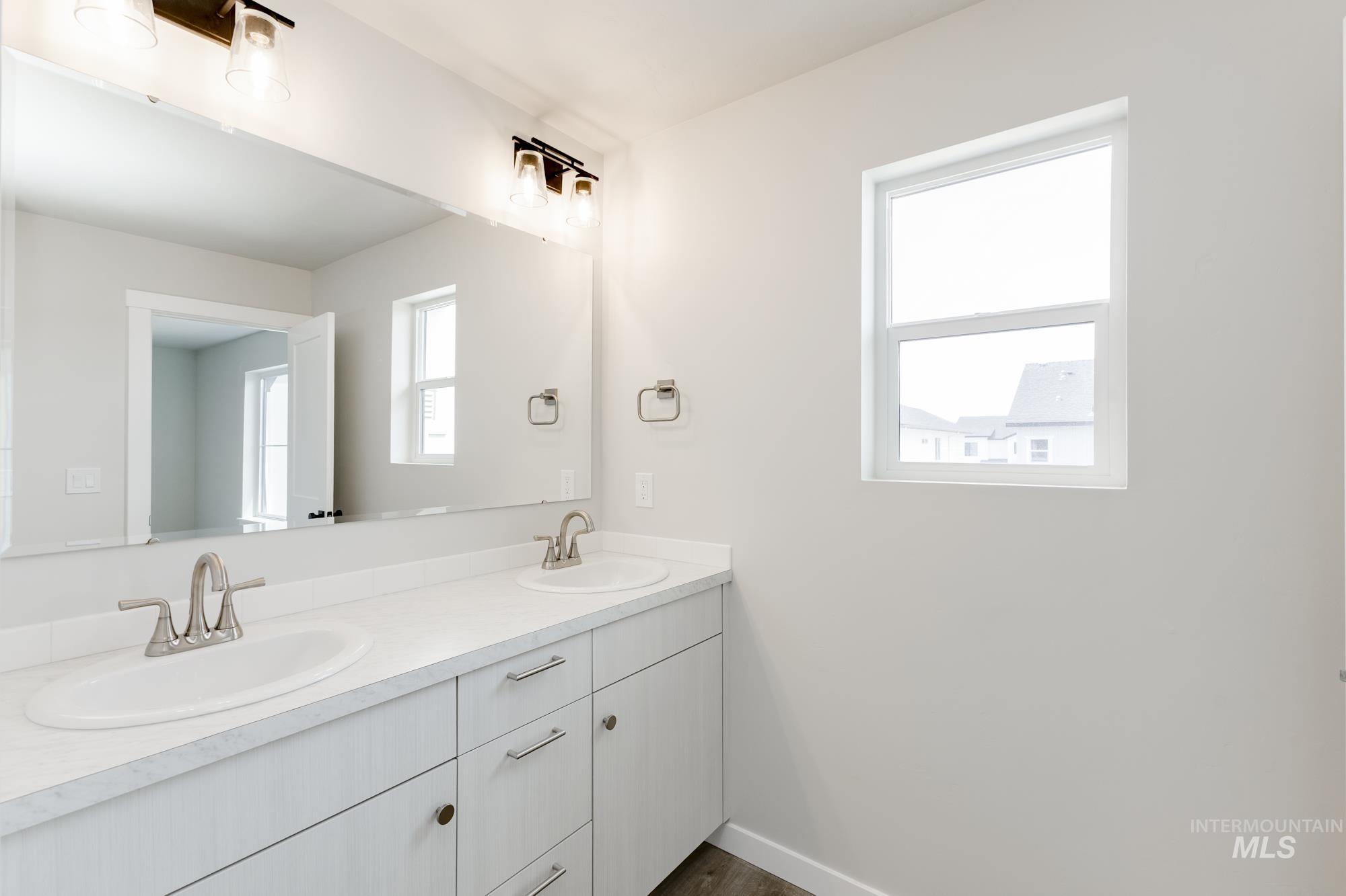 Full bath with double vanity and baseboards
