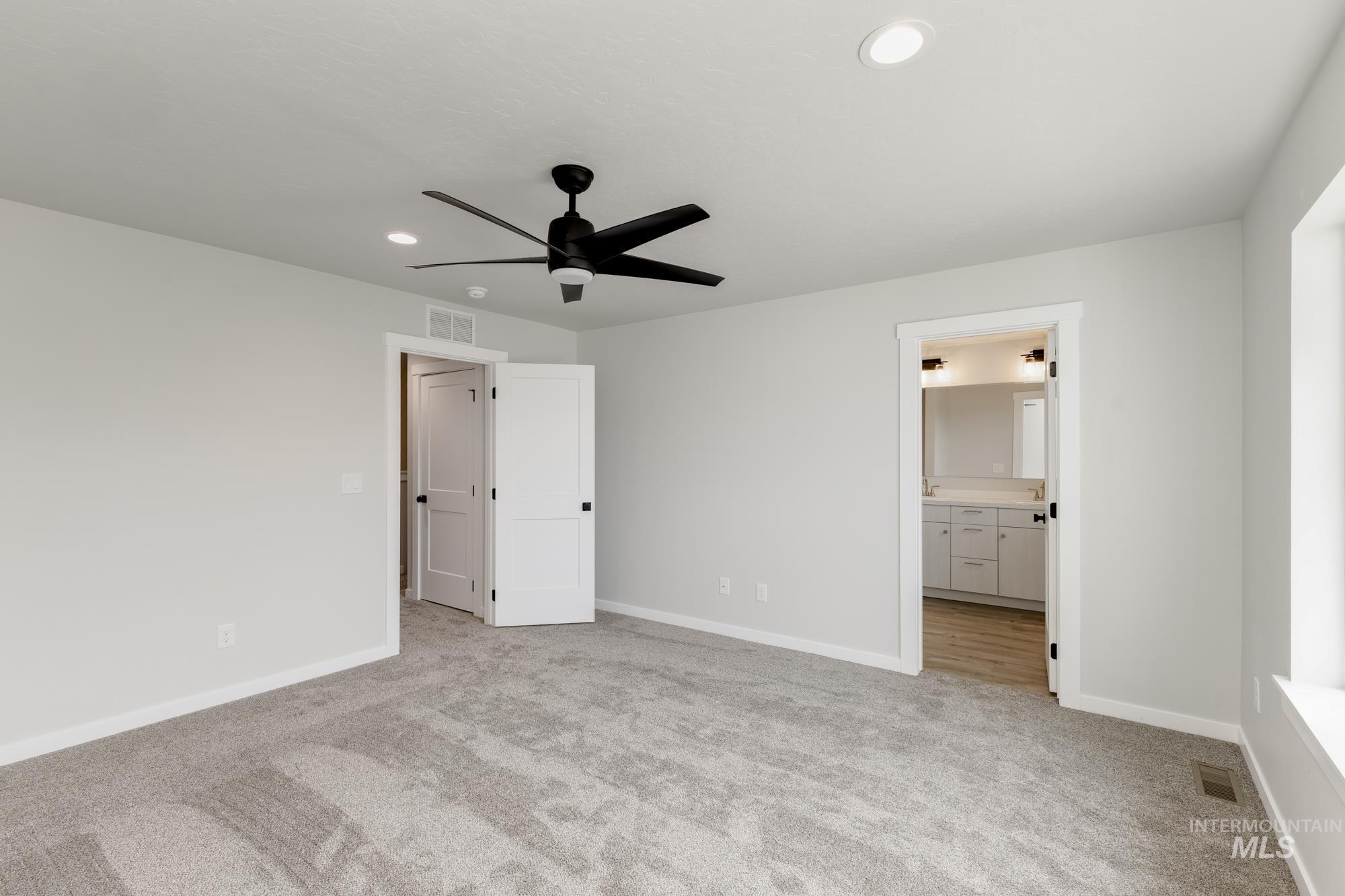 Unfurnished bedroom with light carpet, recessed lighting, a ceiling fan, and ensuite bath