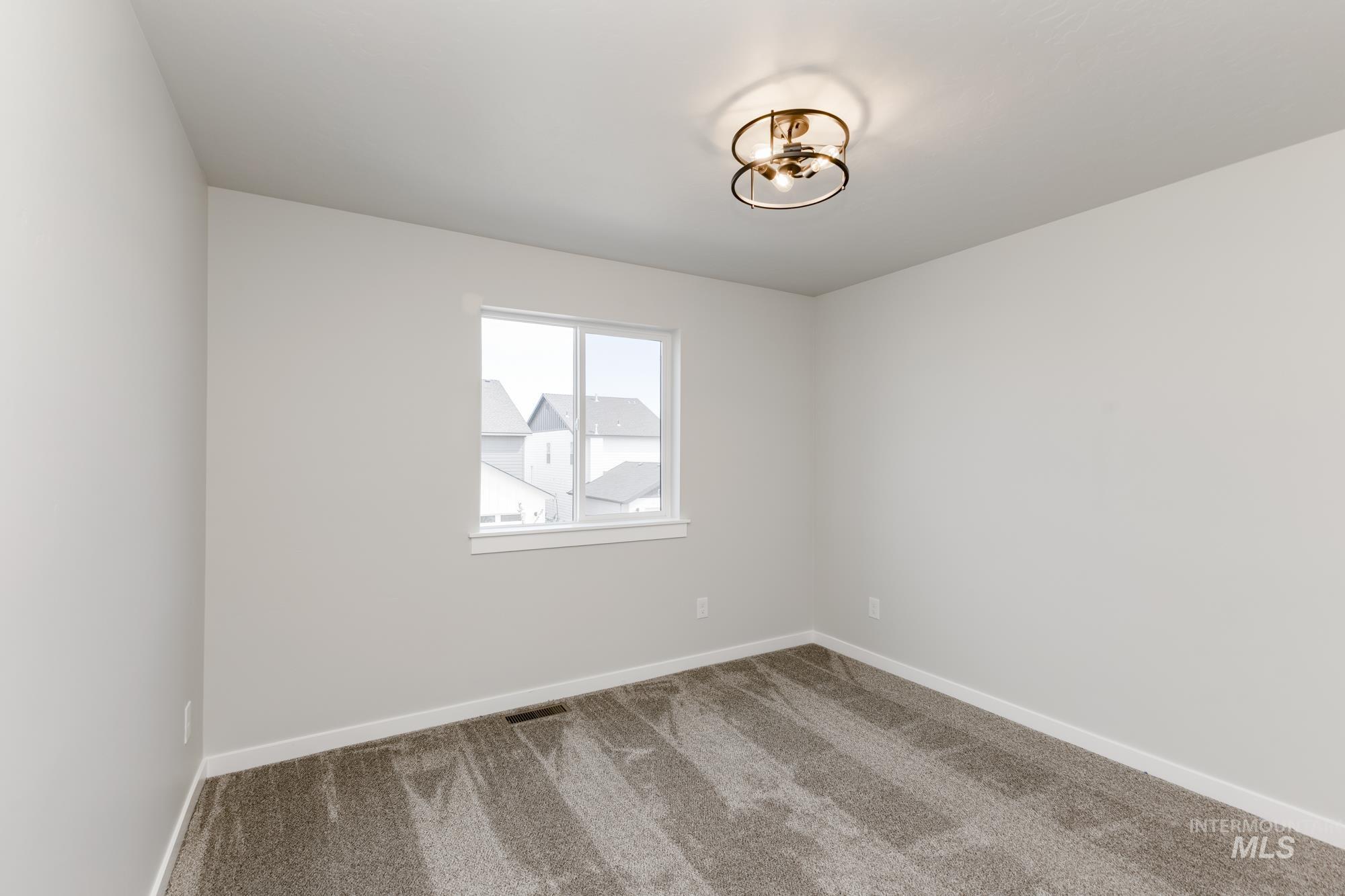 Empty room featuring carpet and baseboards
