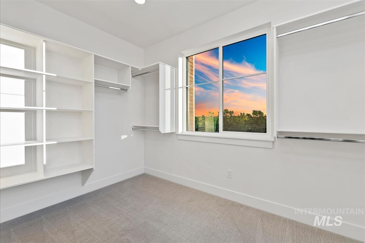 Well-appointed closet space featuring extensive shelving and hanging rods