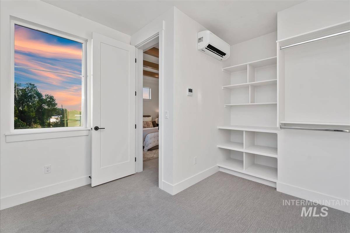 Room featuring light gray carpet flooring, white walls, and a single window with white trim