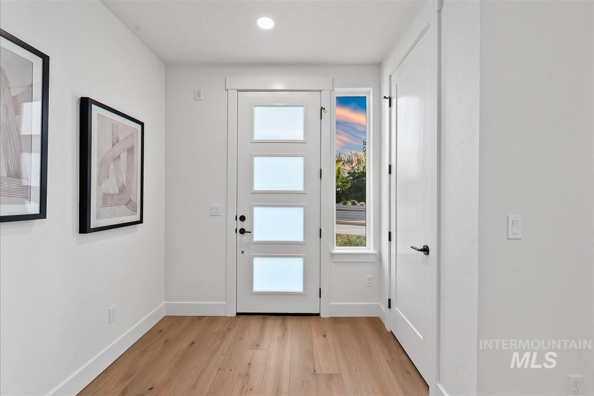 Modern entry door with four frosted glass panels, accompanied by a vertical sidelight