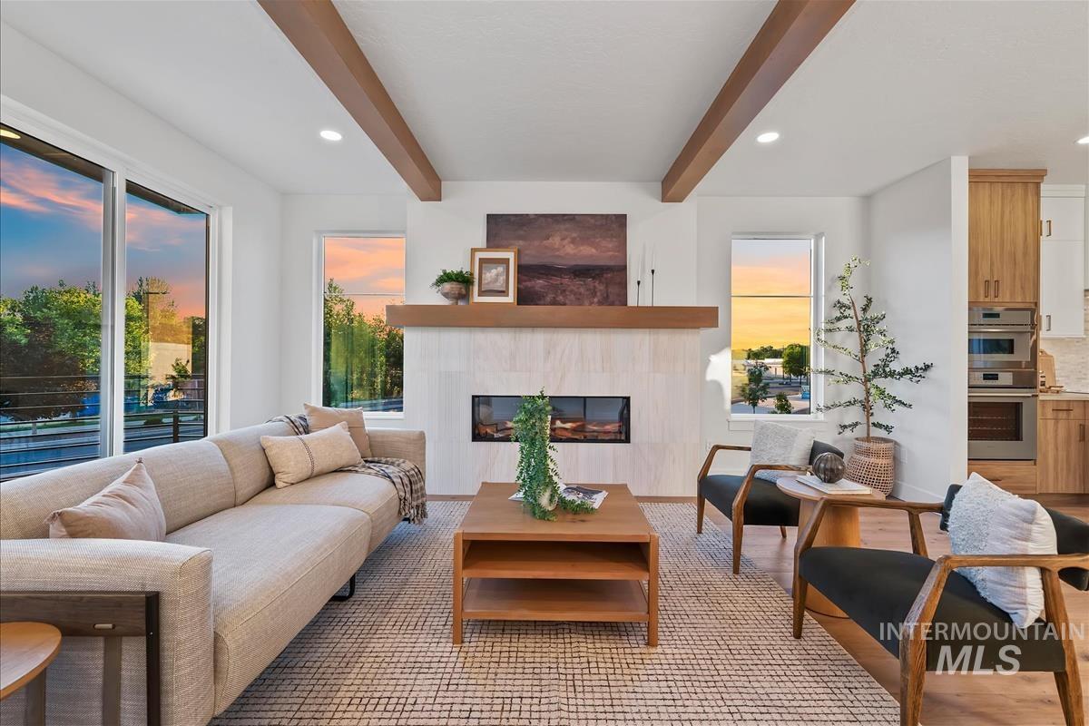 Living area featuring a modern fireplace with a light-colored tile surround and a wood mantel