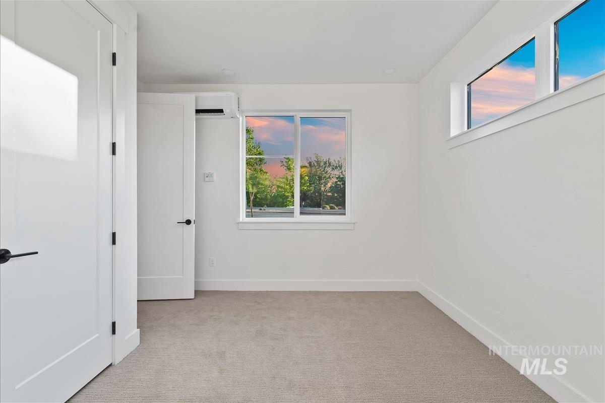 Bright room featuring a large window, high transom window, and light-colored carpeting