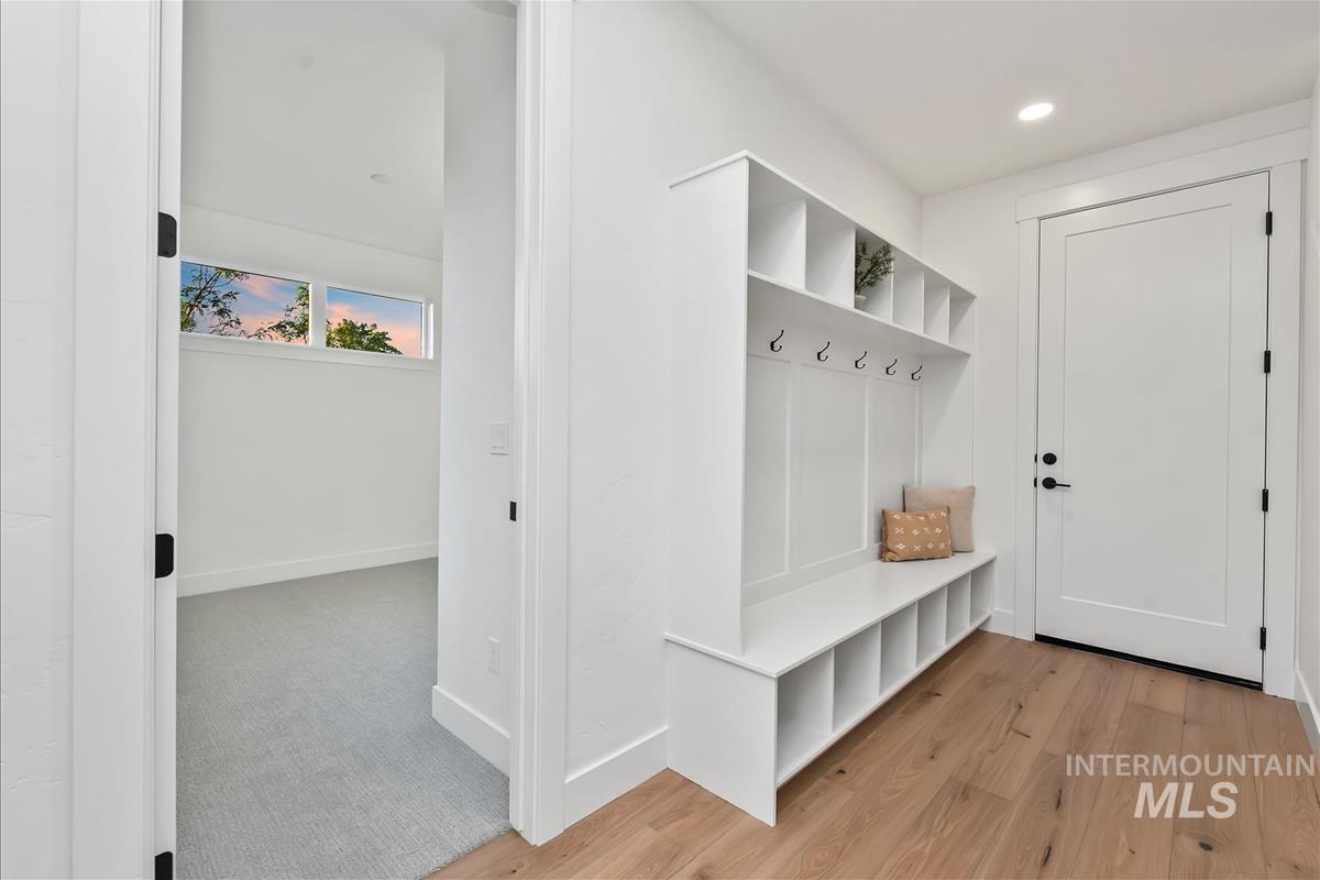 Entryway featuring a built-in white mudroom bench with cubby storage, upper shelving, and coat hooks