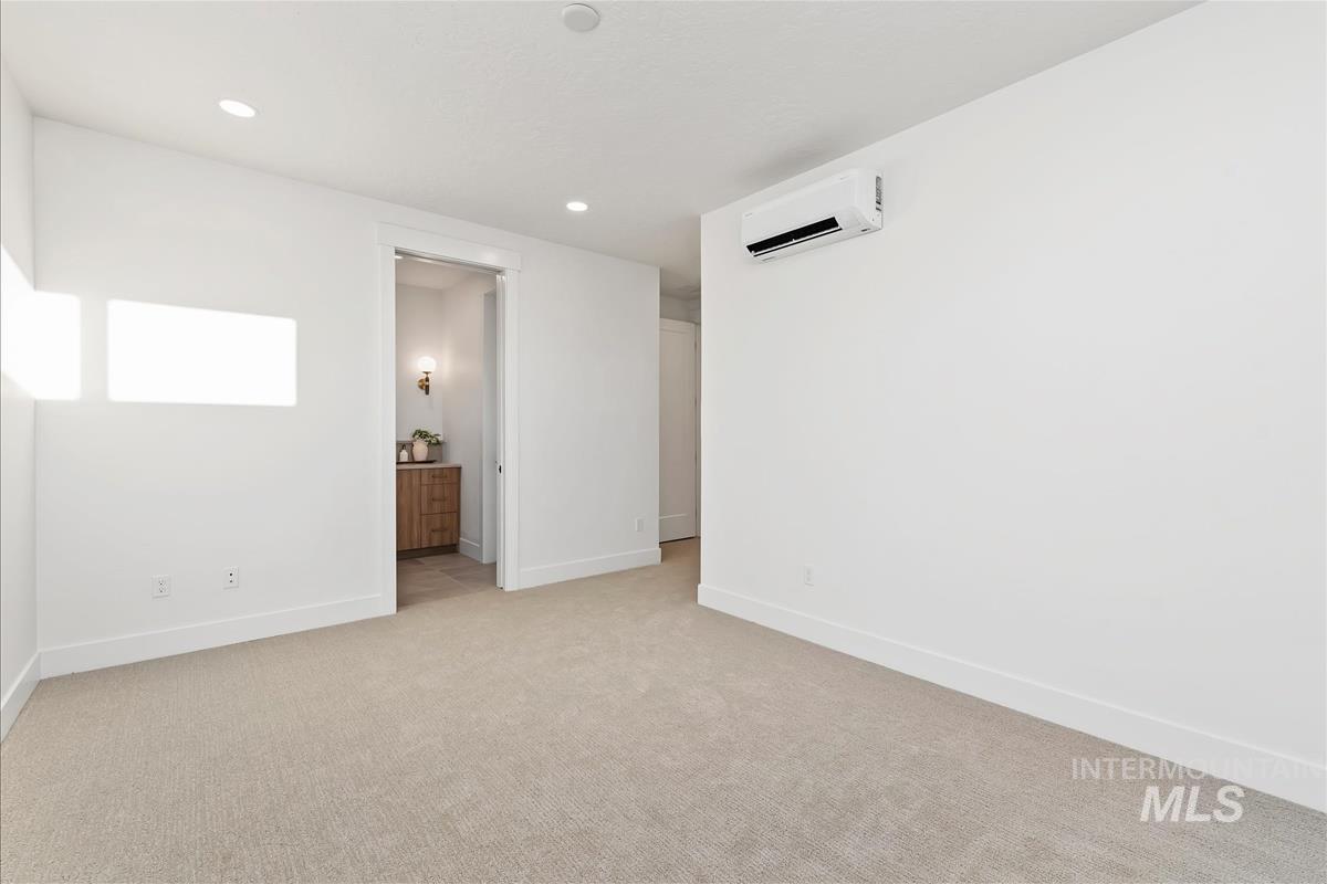 Spacious room featuring neutral carpeting and white baseboards