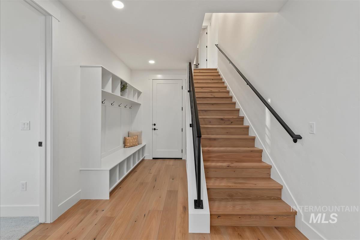 Hardwood flooring throughout the entry area, featuring a built-in storage bench with shelving and coat hooks