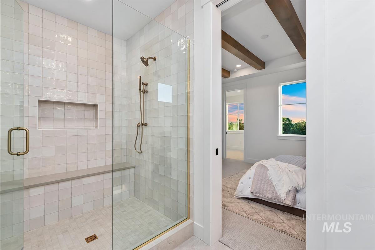 Glass-enclosed shower with subway tile surround, integrated niche, and built-in bench