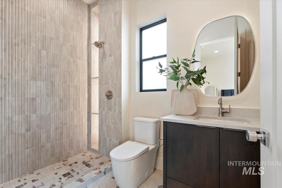 Full bath with vanity and tiled shower