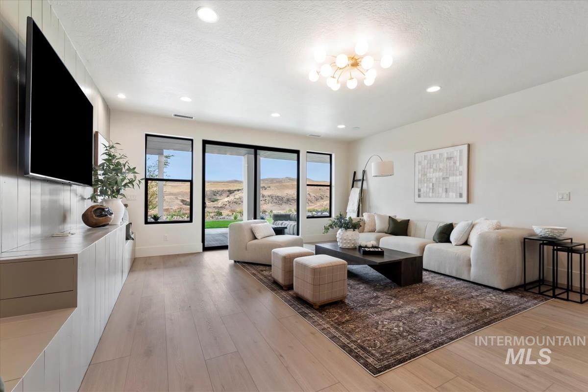 Living room featuring light wood finished floors, recessed lighting, a textured ceiling, and a mountain view