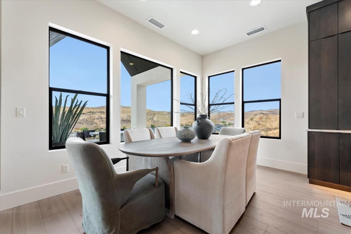 Dining space featuring a mountain view, light wood-style flooring, and recessed lighting