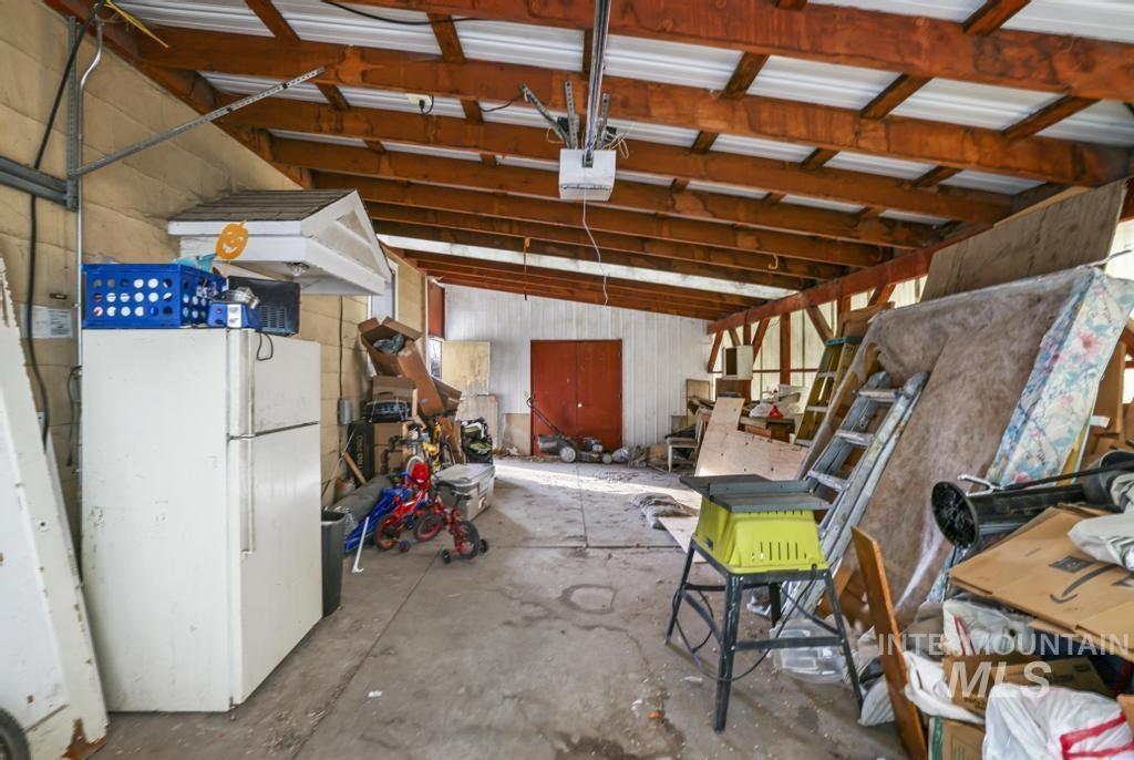 Garage with freestanding refrigerator and a garage door opener