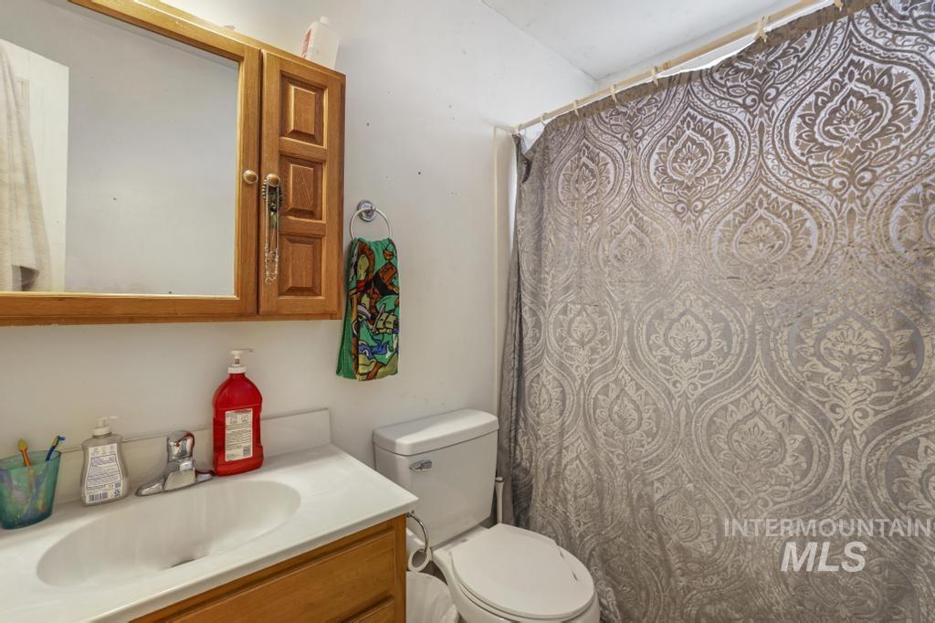 Bathroom featuring a shower with curtain and vanity