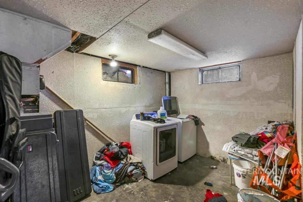 Washroom with unfinished concrete flooring and washer and dryer