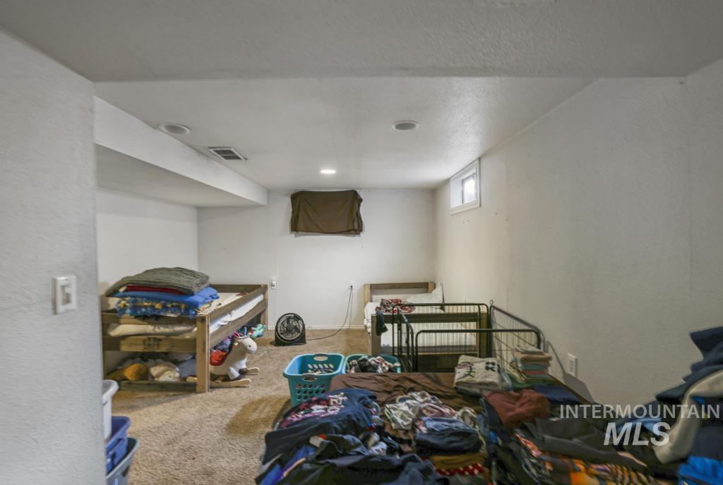 Bedroom with carpet, a textured ceiling, and a textured wall