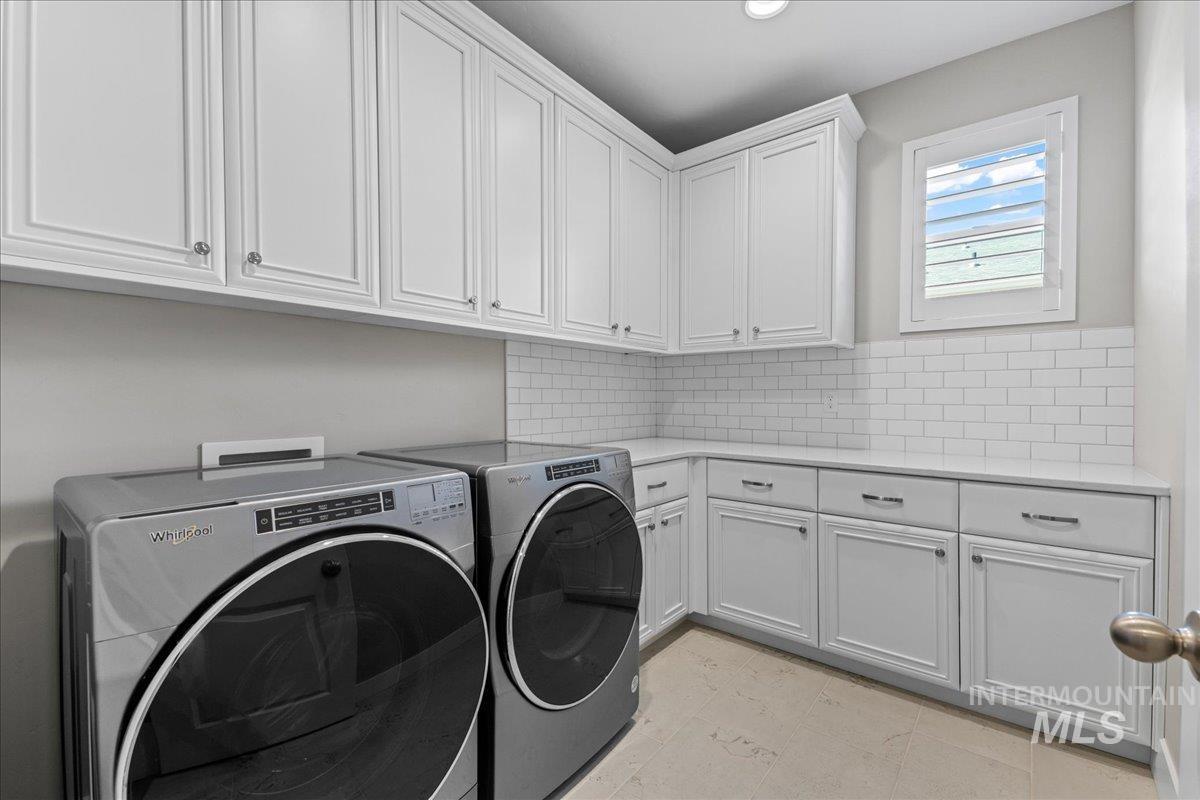 Laundry room with washing machine and clothes dryer, cabinet space, and recessed lighting