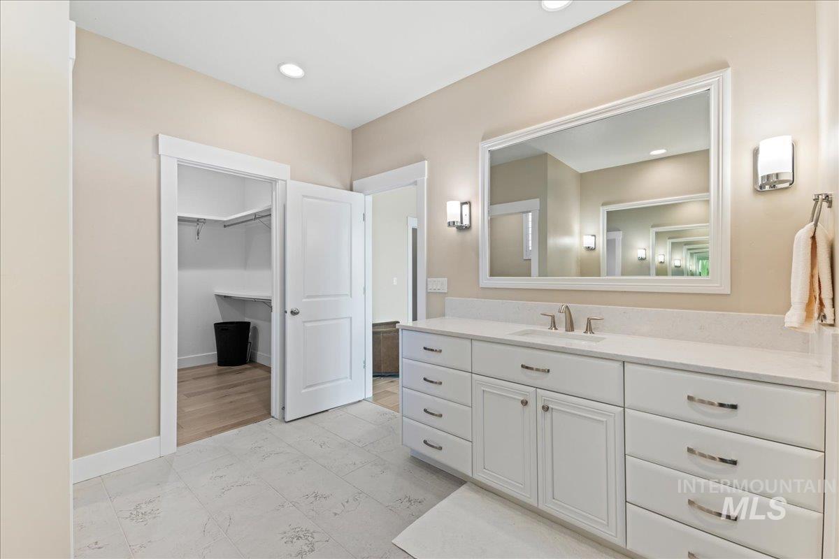 Bathroom featuring vanity, recessed lighting, and a spacious closet