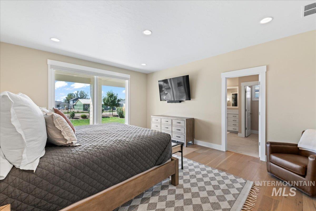Bedroom with light wood-style floors, recessed lighting, and access to exterior