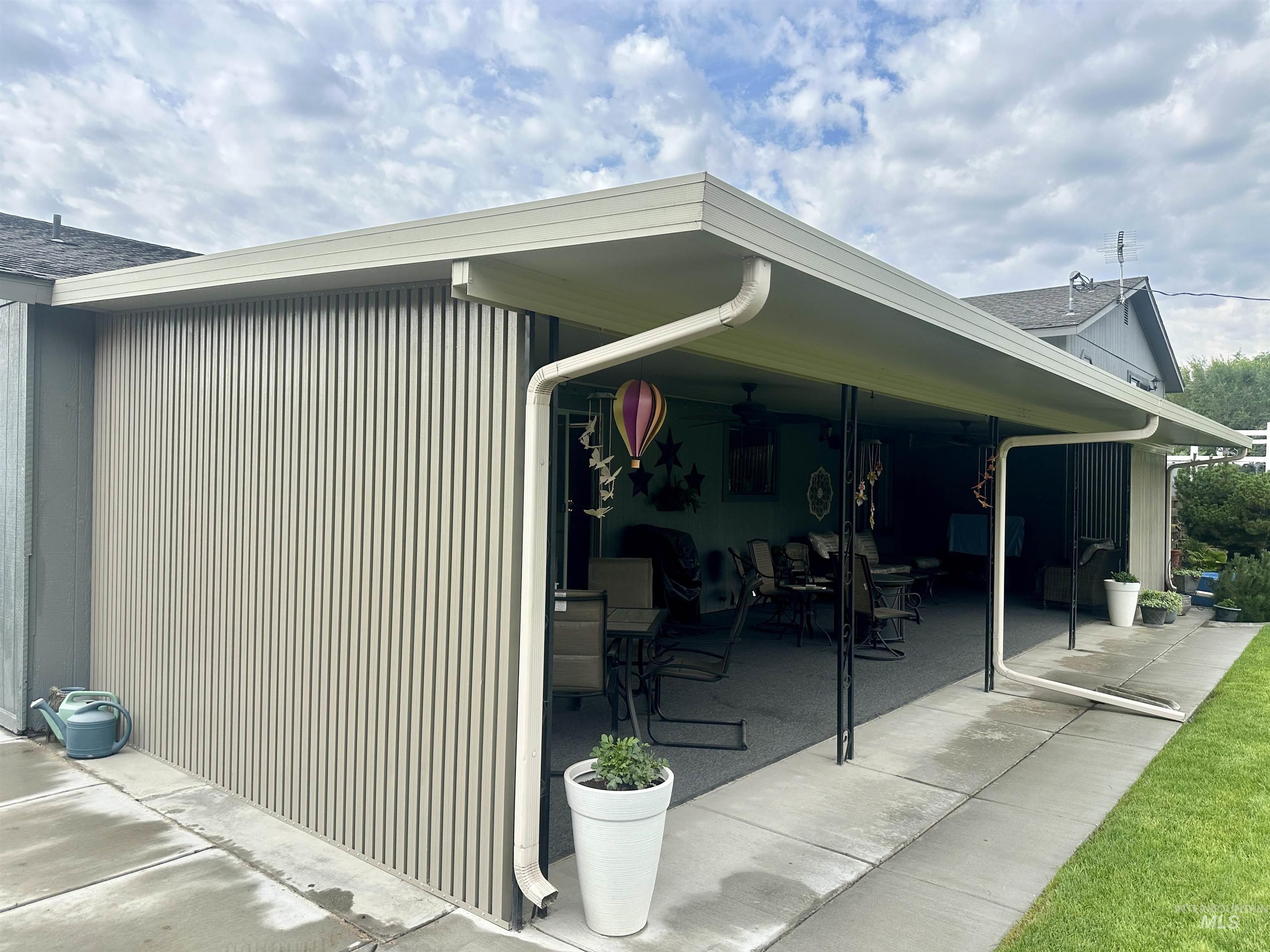 View of property exterior with a ceiling fan and a patio