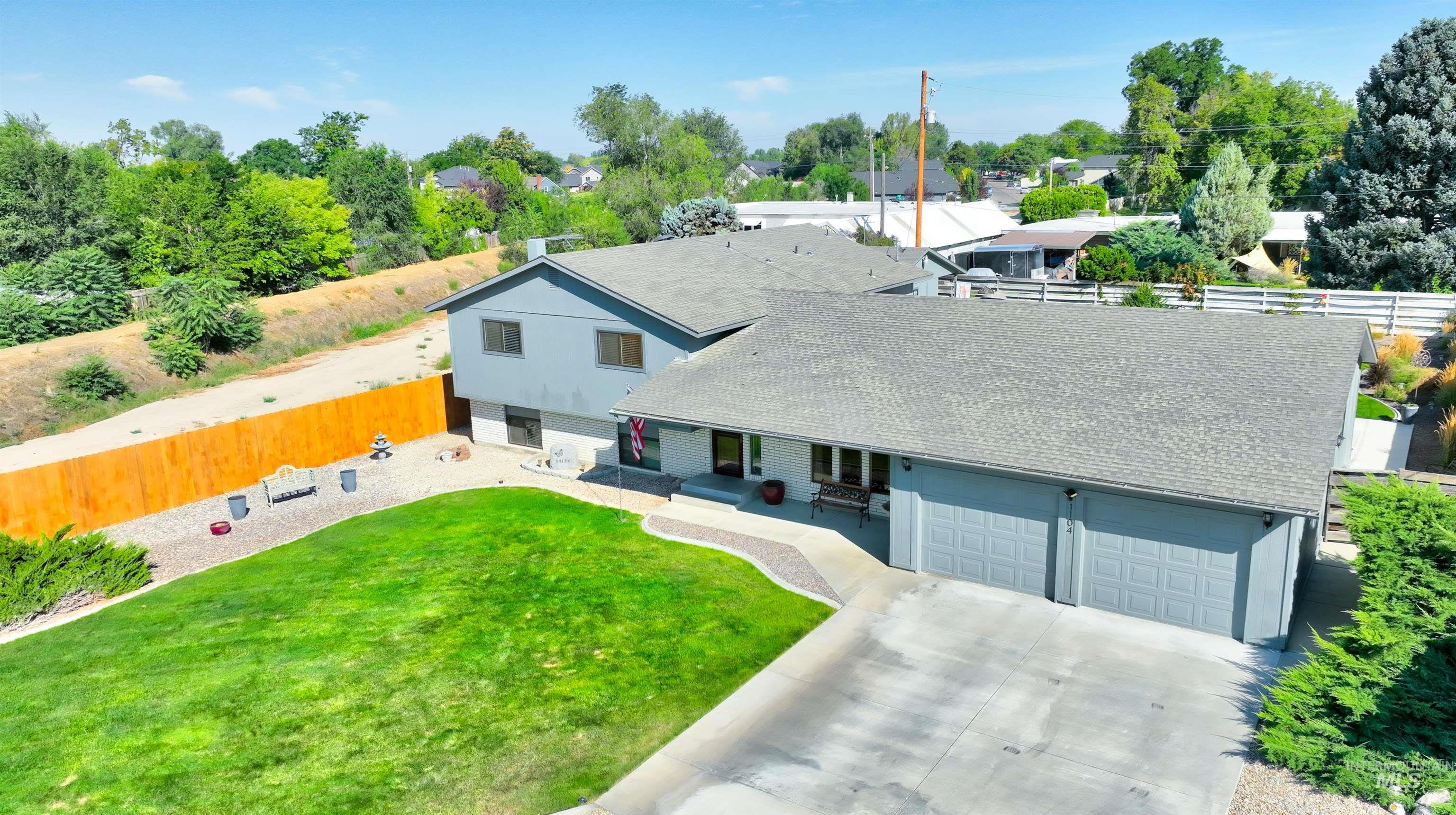 Aerial view of property and surrounding area featuring a tree filled landscape