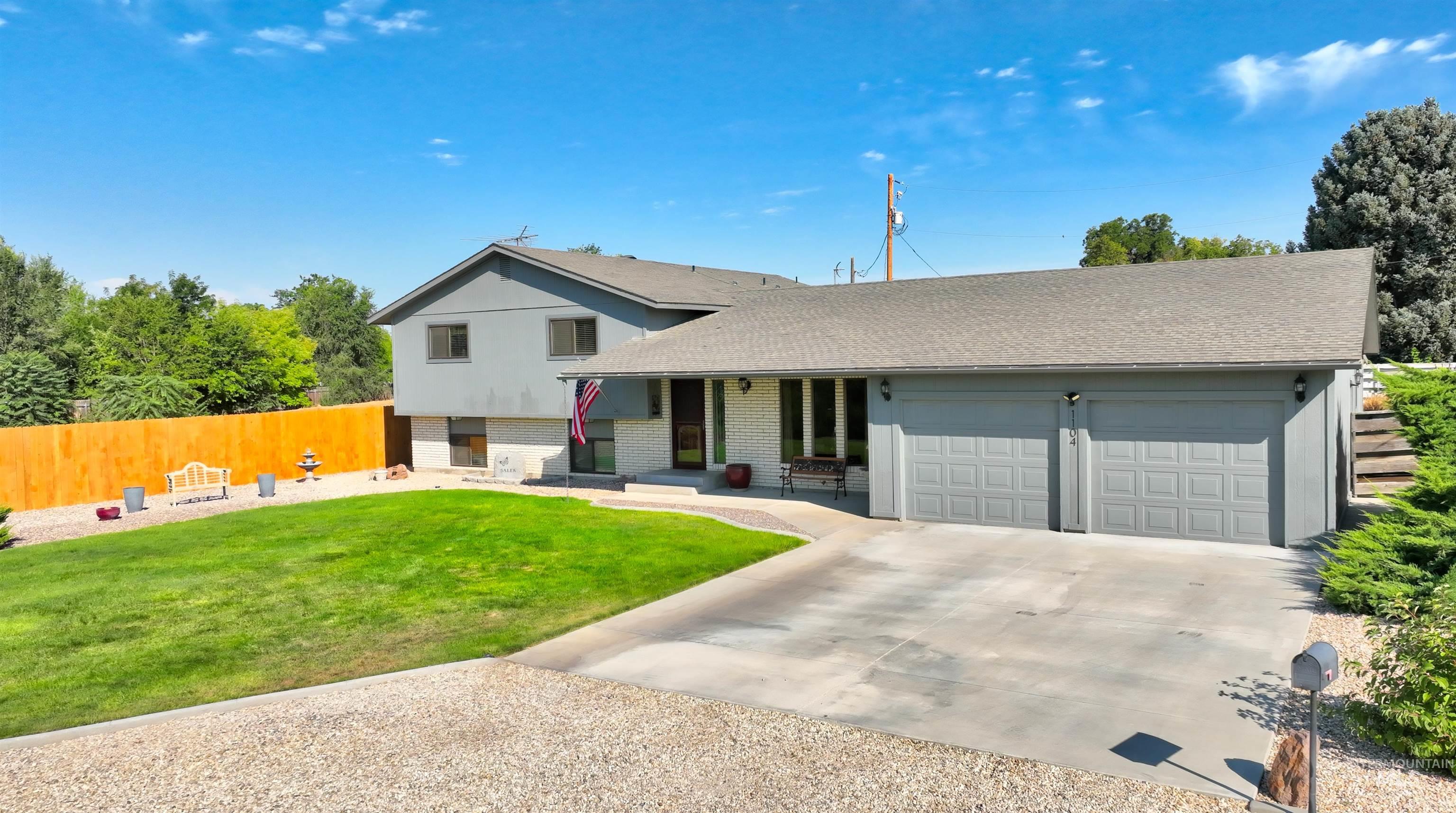 Split level home with brick siding, concrete driveway, and a shingled roof