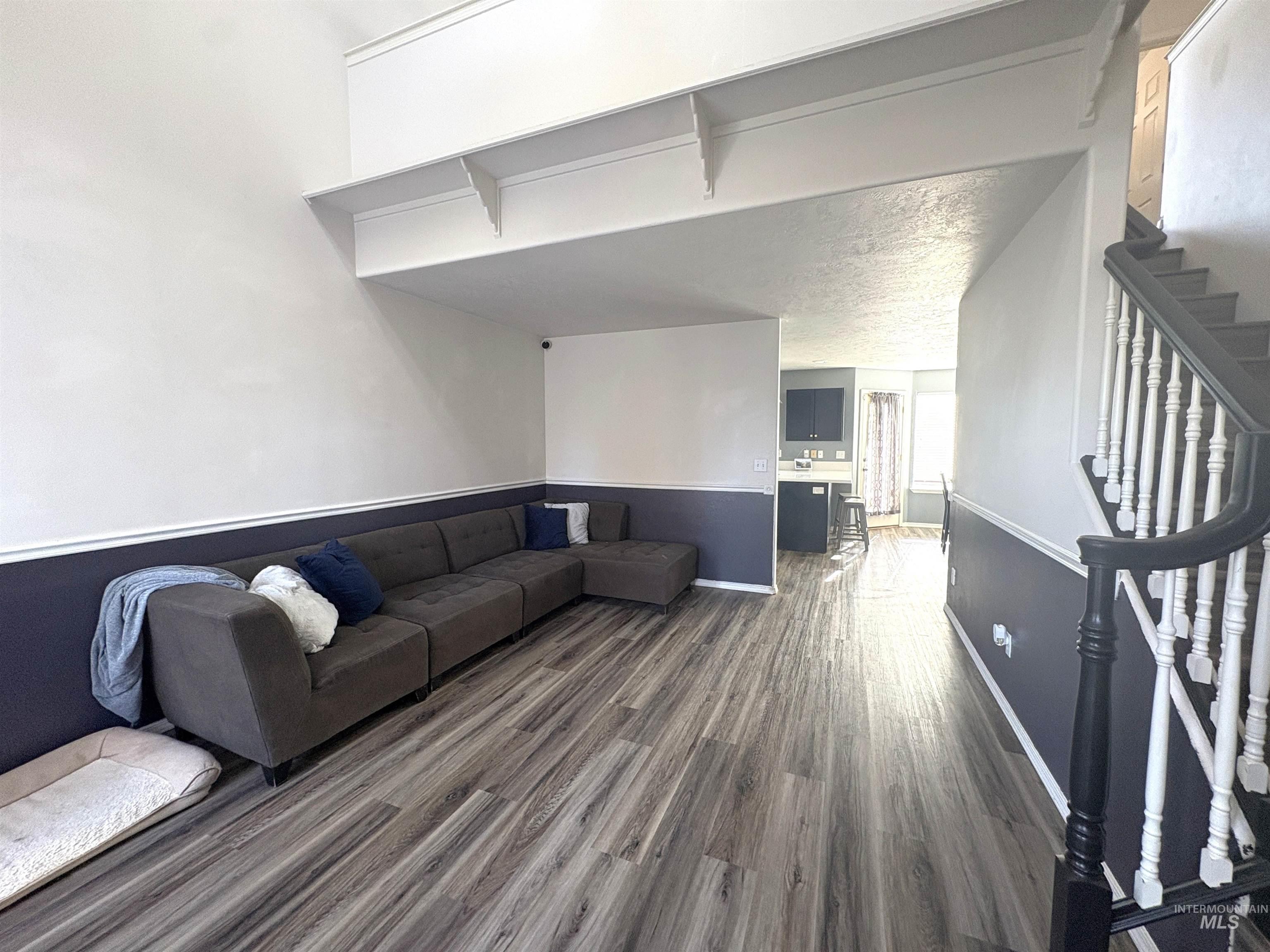 Living area featuring stairway and dark wood-style flooring