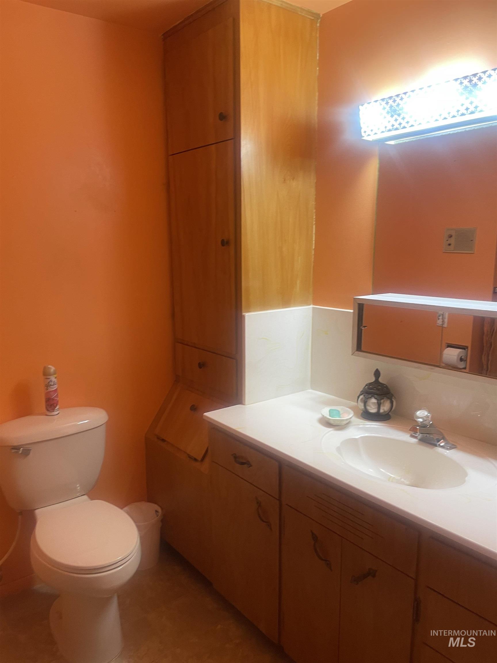 Half bathroom featuring vanity and toilet