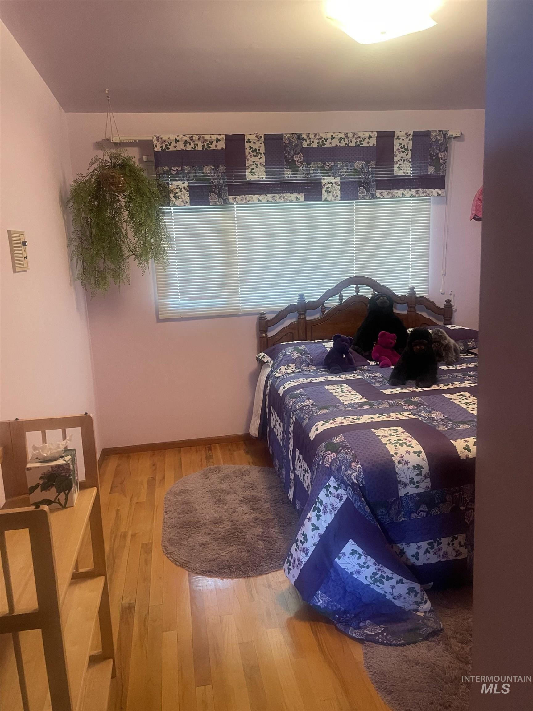Bedroom featuring wood finished floors and baseboards