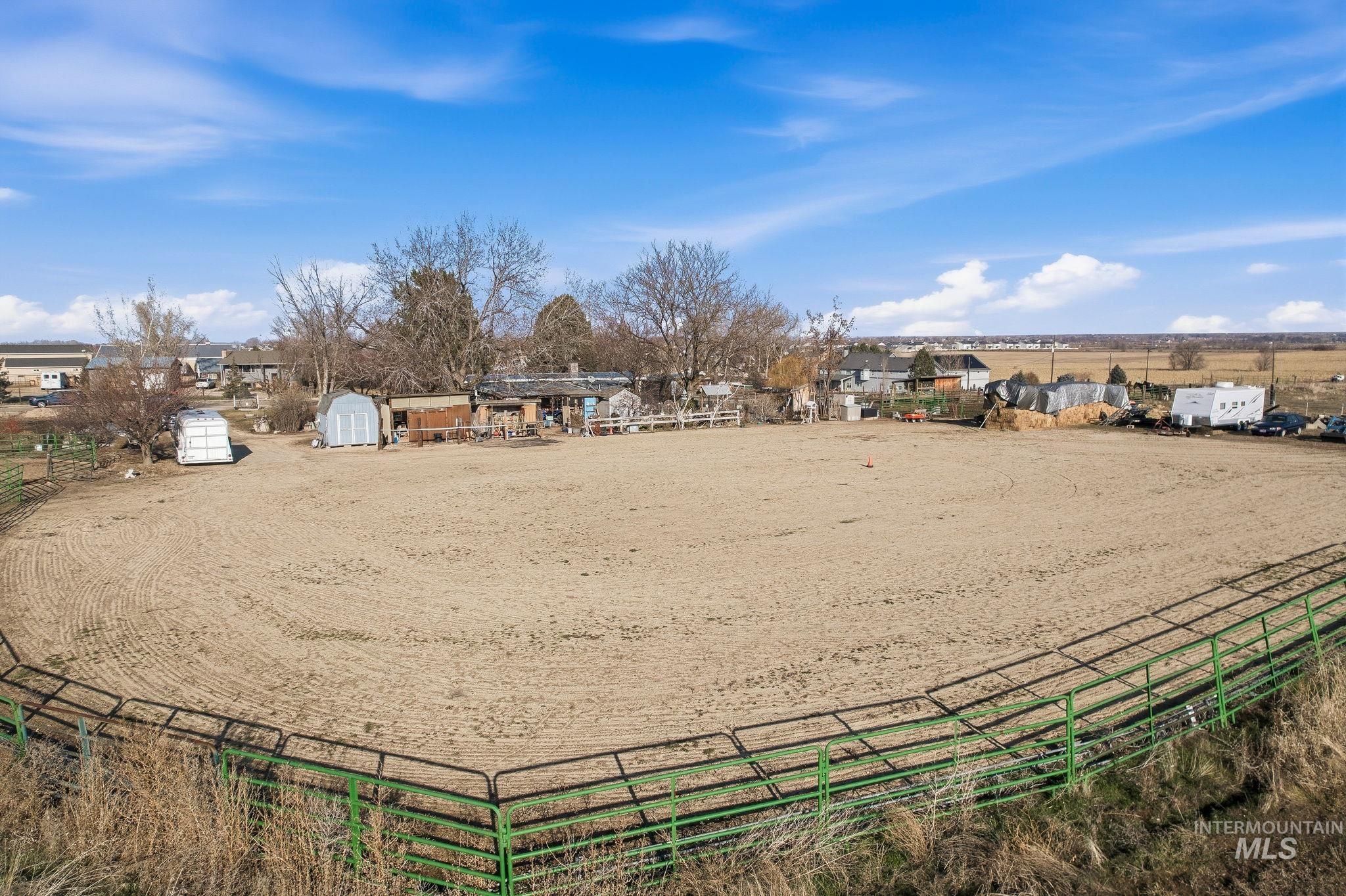 View of property's community with an enclosed horse arena, a rural view, and an outdoor structure