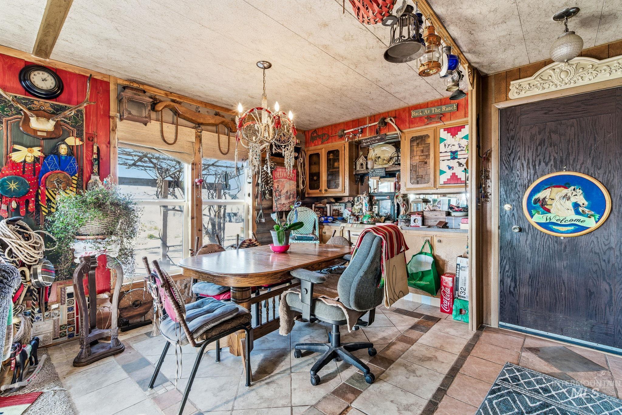 Dining area with inlaid floor details, wooden walls, a chandelier, and light tile patterned floors